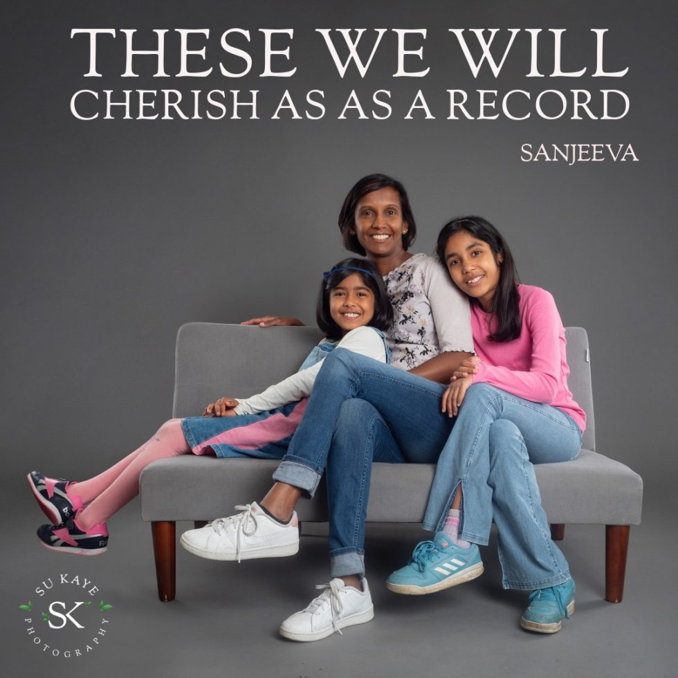 Family portrait of a woman and two girls sitting on a couch, smiling, under text 