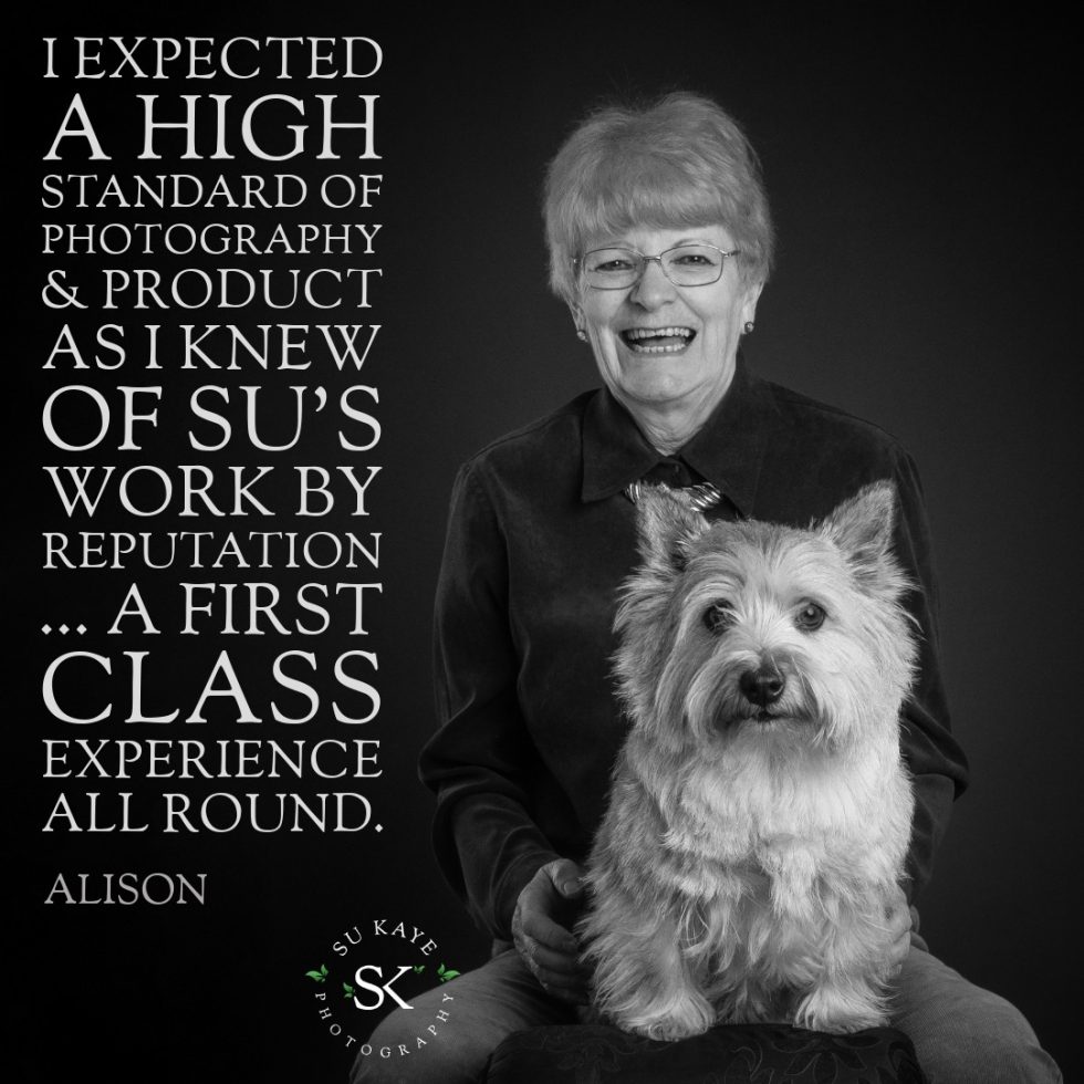 A black-and-white image of an elderly woman smiling, sitting with a west highland terrier, with a testimonial about photography services overlayed.